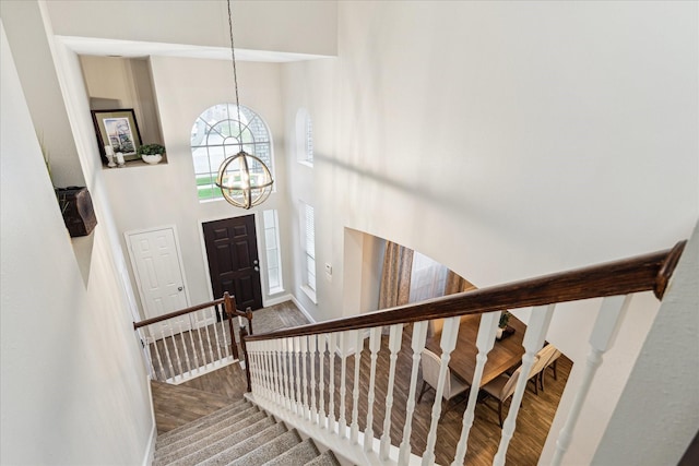 17815 Fairgrove Park Dr, Houston, TX 77095 - staircase with a chandelier, wood finished floors, a towering ceiling, and baseboards