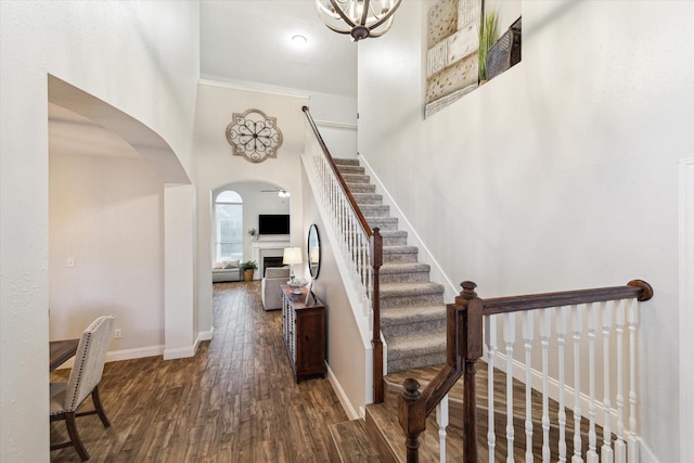 17815 Fairgrove Park Dr, Houston, TX 77095 - entryway with a fireplace, dark wood-type flooring, baseboards, arched walkways, and stairway
