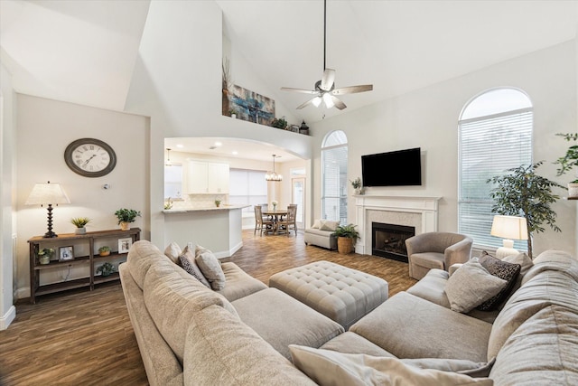 17815 Fairgrove Park Dr, Houston, TX 77095 - living room featuring a ceiling fan, arched walkways, baseboards, dark wood finished floors, and high vaulted ceiling