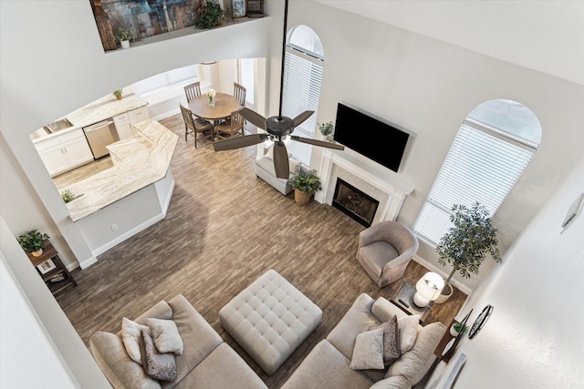 17815 Fairgrove Park Dr, Houston, TX 77095 - living room with a fireplace, a towering ceiling, wood finished floors, and baseboards