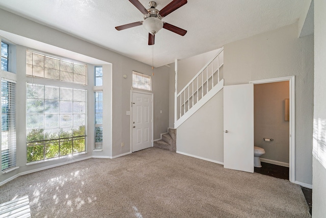 1502 Stevenage Ln, Channelview, TX 77530 - foyer entrance with carpet flooring, stairs, a ceiling fan, and baseboards