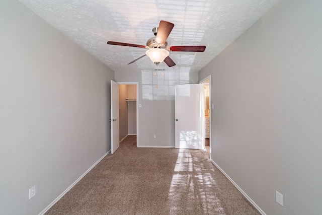 1502 Stevenage Ln, Channelview, TX 77530 - unfurnished bedroom featuring carpet flooring, a textured ceiling, baseboards, a spacious closet, and a ceiling fan