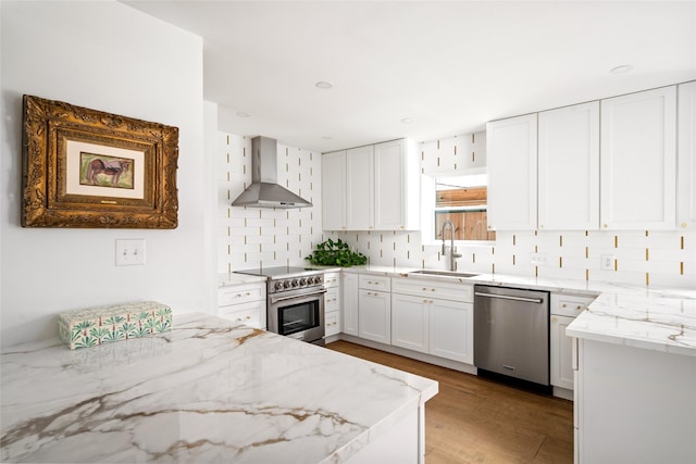 2421 Potomac Dr Unit C, Houston, TX 77057 - kitchen with stainless steel appliances, a sink, wall chimney exhaust hood, light stone countertops, and decorative backsplash