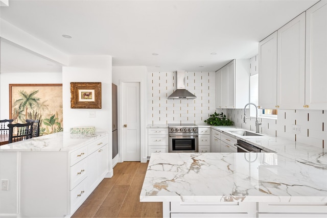 2421 Potomac Dr Unit C, Houston, TX 77057 - kitchen with wall chimney range hood, a sink, a peninsula, stainless steel stove, and light stone countertops