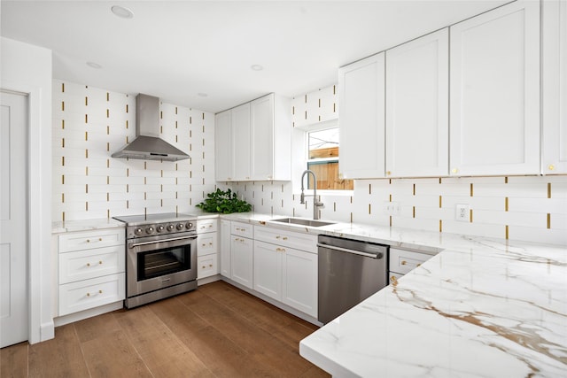 2421 Potomac Dr Unit C, Houston, TX 77057 - kitchen featuring stainless steel appliances, wall chimney range hood, a sink, light stone countertops, and decorative backsplash