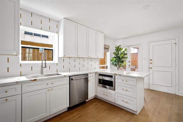 2421 Potomac Dr Unit C, Houston, TX 77057 - kitchen with appliances with stainless steel finishes, a sink, a peninsula, and plenty of natural light