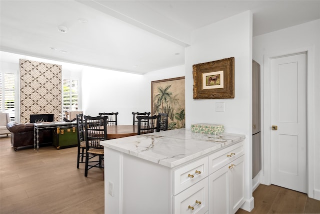 2421 Potomac Dr Unit C, Houston, TX 77057 - kitchen featuring light wood finished floors, white cabinetry, light stone countertops, open floor plan, and a tiled fireplace