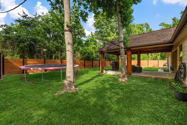 14940 Constellation Cir W, Willis, TX 77318 - view of yard featuring a trampoline and a patio area