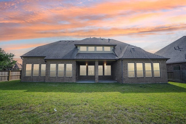 3115 Hillside Landing Trl, Katy, TX 77494 - back of house at dusk with brick siding, a patio area, and roof with shingles