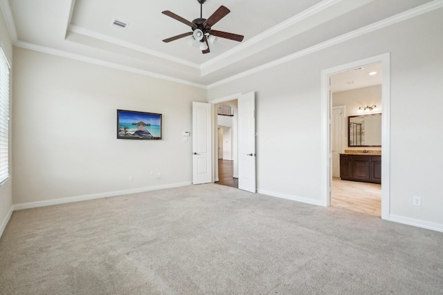 3115 Hillside Landing Trl, Katy, TX 77494 - unfurnished bedroom featuring a tray ceiling, light colored carpet, ornamental molding, baseboards, and ensuite bath