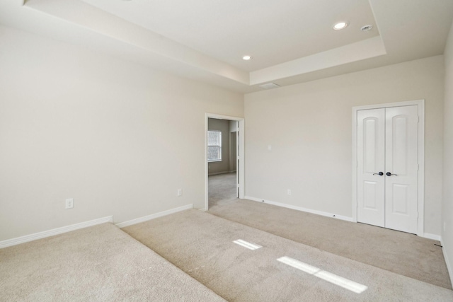 3115 Hillside Landing Trl, Katy, TX 77494 - unfurnished bedroom with carpet flooring, recessed lighting, baseboards, a tray ceiling, and a closet