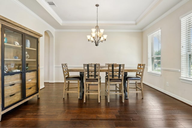 3115 Hillside Landing Trl, Katy, TX 77494 - dining room featuring a tray ceiling, a chandelier, ornamental molding, dark wood-style flooring, and arched walkways