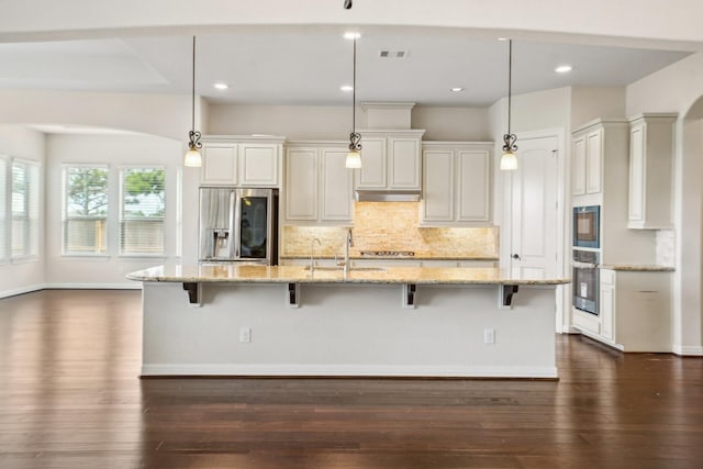 3115 Hillside Landing Trl, Katy, TX 77494 - kitchen with appliances with stainless steel finishes, a breakfast bar area, backsplash, dark wood-style flooring, and recessed lighting