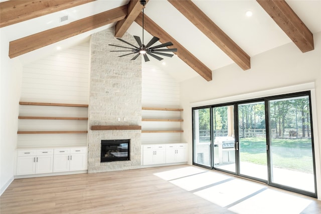 21332 Monarch Dr, Montgomery, TX 77316 - unfurnished living room featuring a stone fireplace, light wood finished floors, beamed ceiling, high vaulted ceiling, and ceiling fan