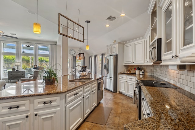2850 Woodland Glen Ln, Conroe, TX 77385 - kitchen with stainless steel appliances, a sink, tasteful backsplash, white cabinets, and hanging light fixtures