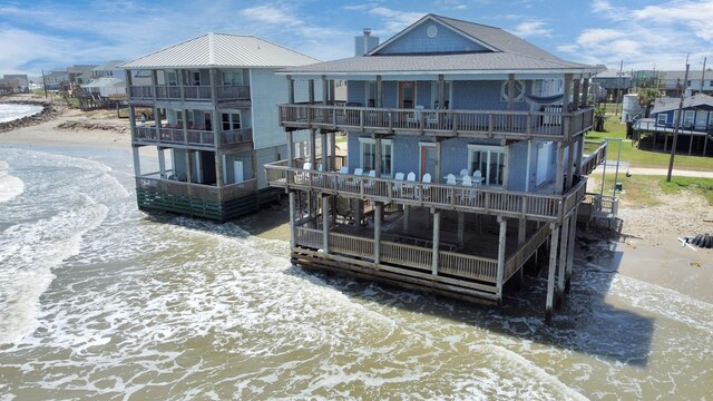 13134 Gulf Beach Dr, Freeport, TX 77541 - rear view of property with a balcony, a shingled roof, a water view, and a chimney