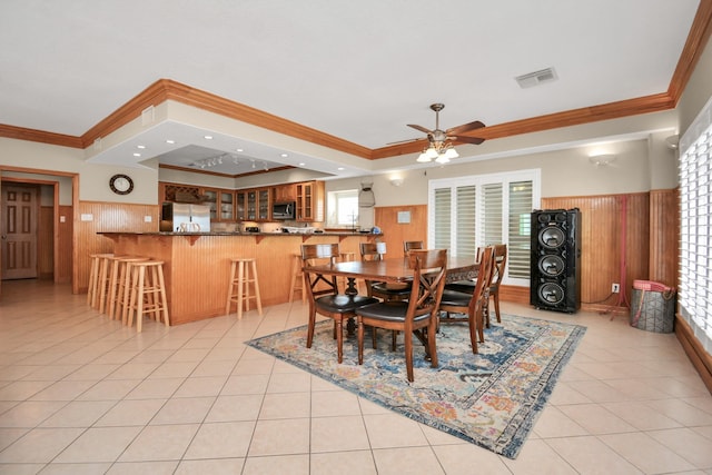 13134 Gulf Beach Dr, Freeport, TX 77541 - dining space with crown molding, a wainscoted wall, a ceiling fan, wooden walls, and light tile patterned floors