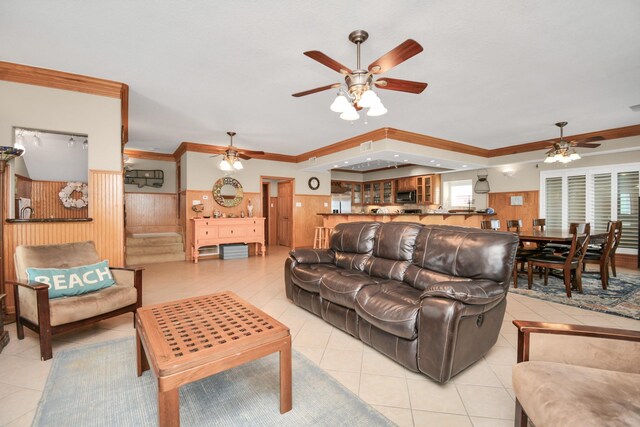 13134 Gulf Beach Dr, Freeport, TX 77541 - living room featuring a ceiling fan, light tile patterned floors, crown molding, and wainscoting