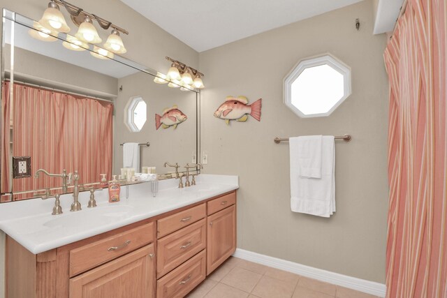 13134 Gulf Beach Dr, Freeport, TX 77541 - bathroom with double vanity, tile patterned floors, and baseboards