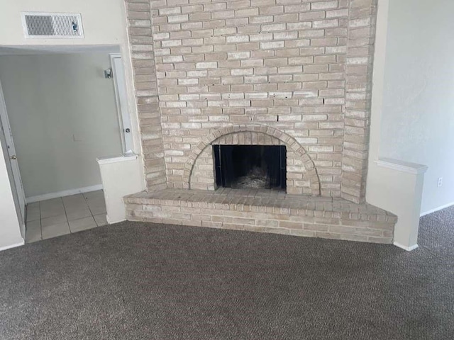 detailed view of carpet, a brick fireplace, and baseboards