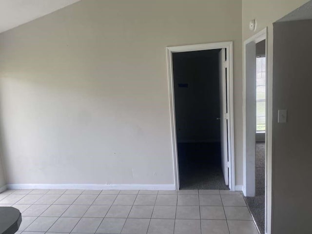 spare room with light tile patterned flooring and baseboards