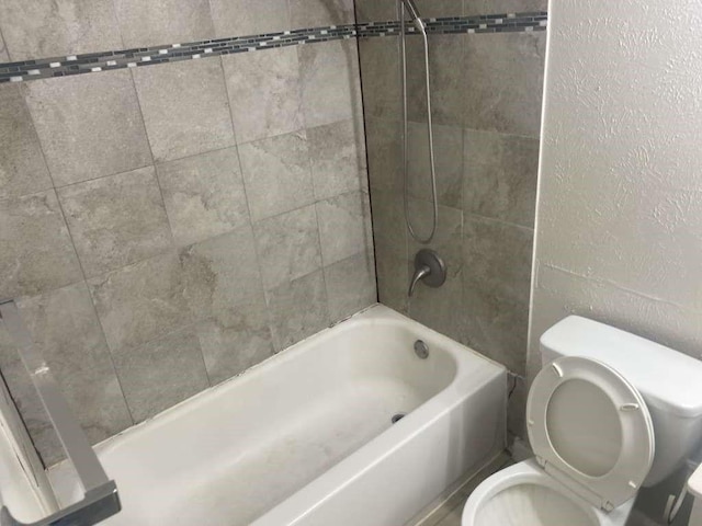 bathroom with toilet and bathing tub / shower combination