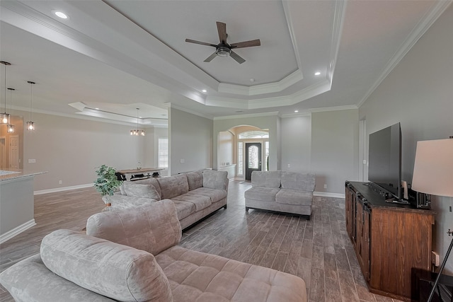 3331 Bridgette Ln, Baytown, TX 77523 - living area featuring arched walkways, a raised ceiling, a ceiling fan, wood finished floors, and crown molding