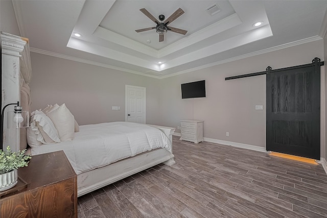 3331 Bridgette Ln, Baytown, TX 77523 - bedroom featuring a barn door, a raised ceiling, wood finished floors, crown molding, and baseboards