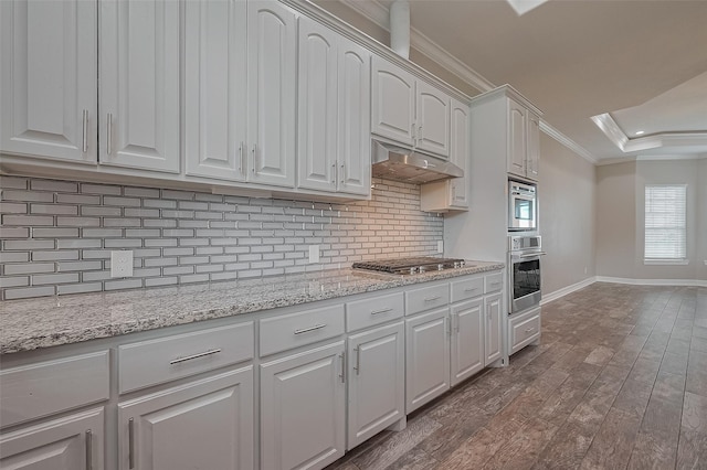 3331 Bridgette Ln, Baytown, TX 77523 - kitchen featuring stainless steel appliances, under cabinet range hood, crown molding, baseboards, and backsplash