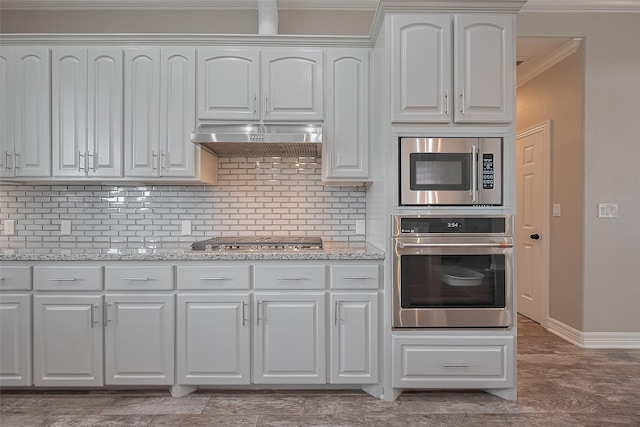 3331 Bridgette Ln, Baytown, TX 77523 - kitchen with stainless steel appliances, exhaust hood, decorative backsplash, baseboards, and crown molding