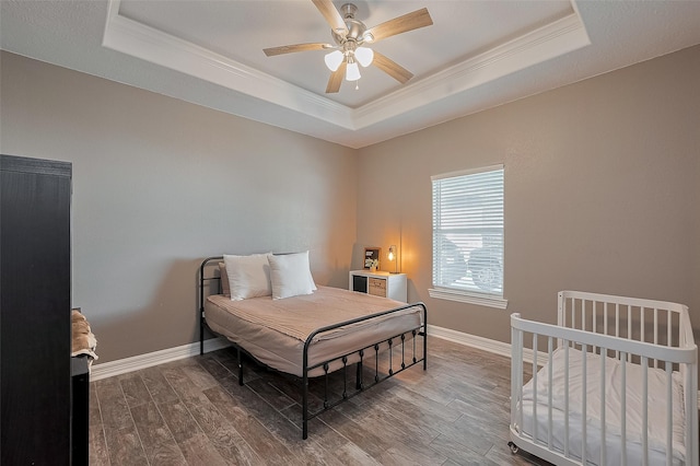 3331 Bridgette Ln, Baytown, TX 77523 - bedroom featuring a raised ceiling, crown molding, dark wood-type flooring, baseboards, and a ceiling fan