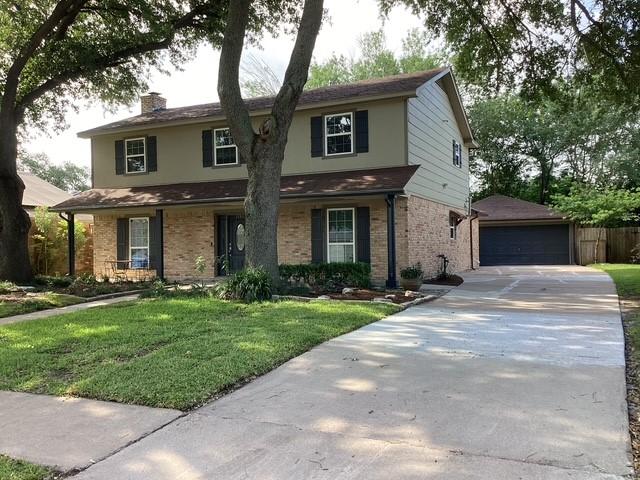15311 Empanada Dr, Houston, TX 77083 - traditional-style house featuring brick siding, an outbuilding, a chimney, and a garage