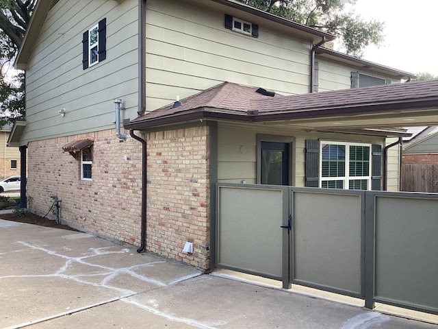 15311 Empanada Dr, Houston, TX 77083 - back of house with brick siding, a shingled roof, and a gate
