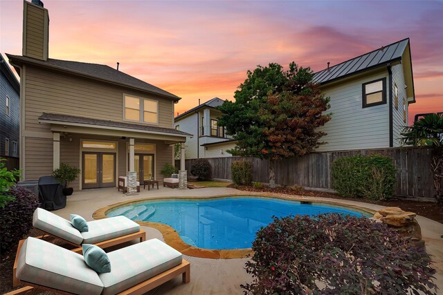814 Nicholson St, Houston, TX 77007 - pool at dusk featuring french doors, a patio area, and a fenced backyard