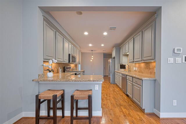 814 Nicholson St, Houston, TX 77007 - kitchen featuring gray cabinets, appliances with stainless steel finishes, tasteful backsplash, a sink, and recessed lighting