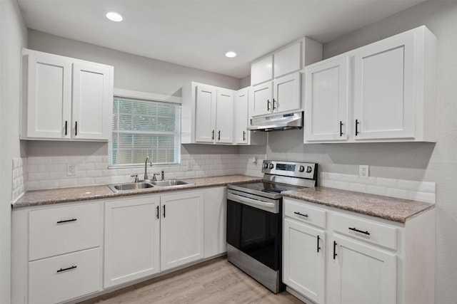 5313 Doolittle Blvd, Houston, TX 77033 - kitchen with stainless steel electric stove, a sink, under cabinet range hood, white cabinetry, and tasteful backsplash