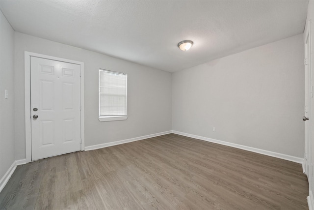5313 Doolittle Blvd, Houston, TX 77033 - spare room featuring wood finished floors, baseboards, and a textured ceiling