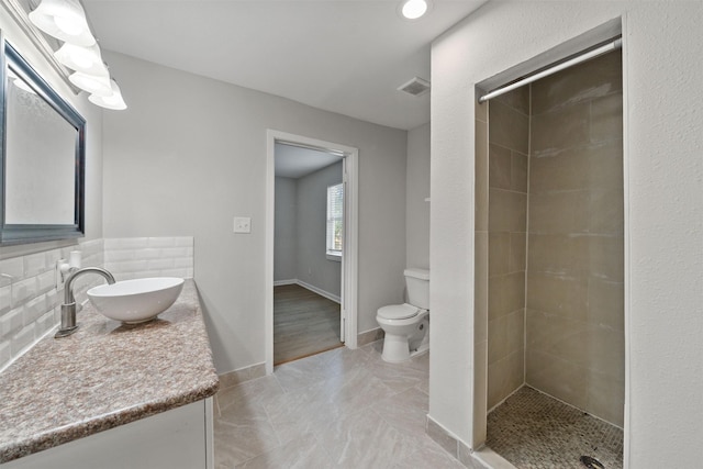 5313 Doolittle Blvd, Houston, TX 77033 - full bathroom with toilet, a tile shower, vanity, and backsplash