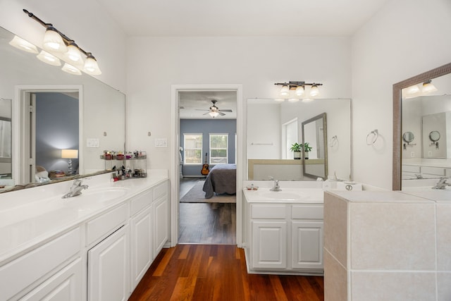full bathroom with connected bathroom, wood finished floors, two vanities, and ceiling fan