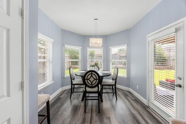 dining space with a chandelier, dark wood-style floors, and baseboards
