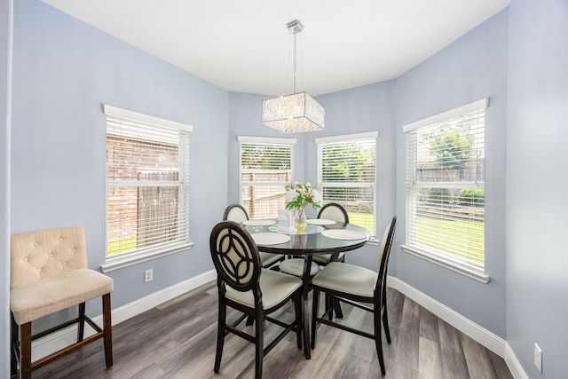 dining space with a chandelier, plenty of natural light, baseboards, and dark wood finished floors
