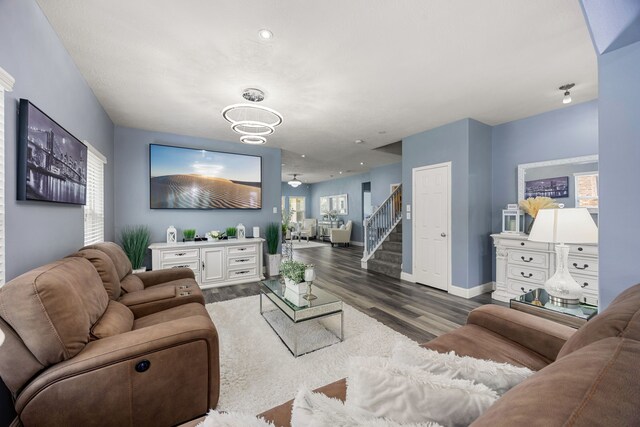 living room with wood finished floors, baseboards, and stairway