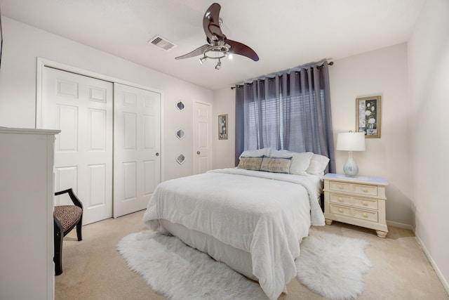 bedroom featuring light carpet, a ceiling fan, and baseboards