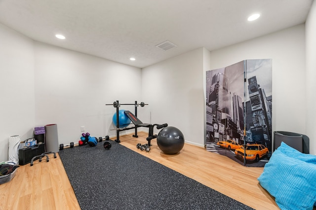 workout area with wood finished floors and recessed lighting