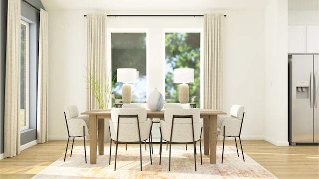 dining space featuring light wood finished floors and baseboards