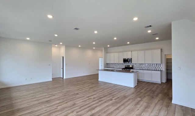 3089 Harrier Dr, Katy, TX 77493 - kitchen with stainless steel appliances, dark countertops, backsplash, open floor plan, and recessed lighting