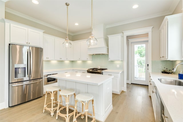 9 Caravelle Ct, Galveston, TX 77554 - kitchen featuring stainless steel appliances, a sink, light wood finished floors, a center island, and recessed lighting