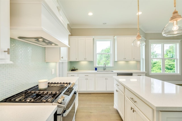 9 Caravelle Ct, Galveston, TX 77554 - kitchen featuring stainless steel gas stove, custom exhaust hood, backsplash, light wood-type flooring, and crown molding