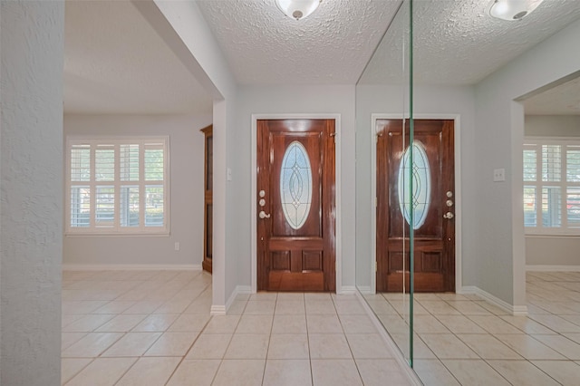 22010 Elsinore Dr, Katy, TX 77450 - foyer with a textured ceiling, plenty of natural light, light tile patterned floors, and baseboards