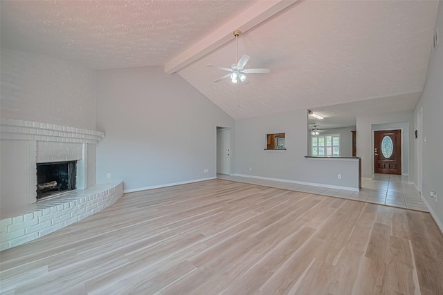 22010 Elsinore Dr, Katy, TX 77450 - unfurnished living room with a ceiling fan, a textured ceiling, light wood-style flooring, a fireplace, and baseboards